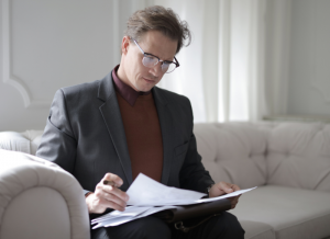 man with glasses reading paper